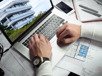 Person, die an ihrem Computer an der Immobilienvermarktung arbeitet | MAXXIMM - Immobilienmarketing für Neubau und Bestand | MAXXIMM - Immobilienmarketing für Neubau und Bestand